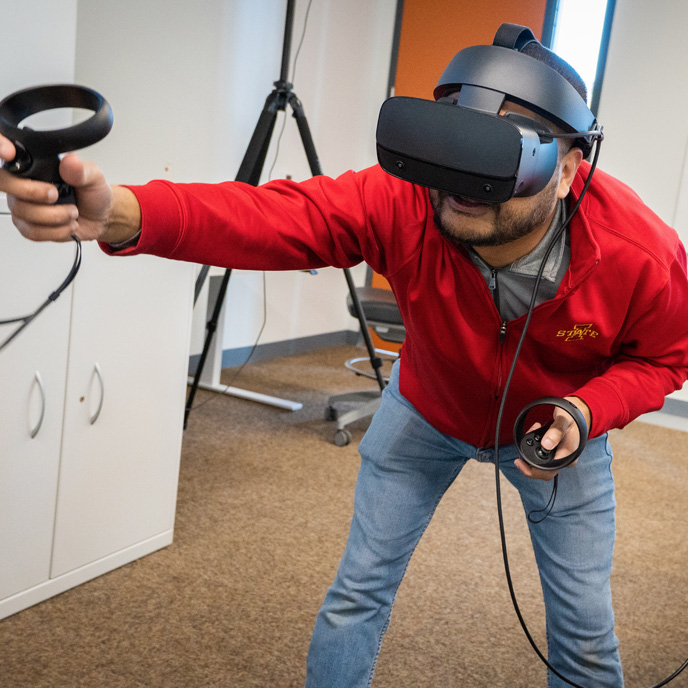 Student wearing virtual reality headset and holding controllers