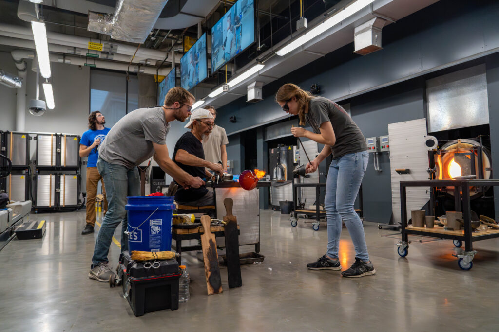 Image of a glassblowing session in action on the main floor of the Student Innovation Center at Gaffers' Guild.